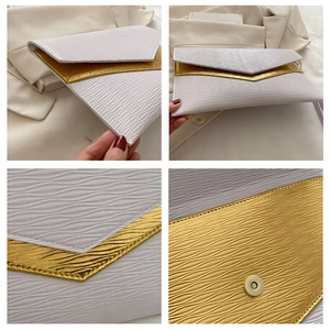 Detail view of pearl white envelope clutch bag with water ripple texture and gold trim