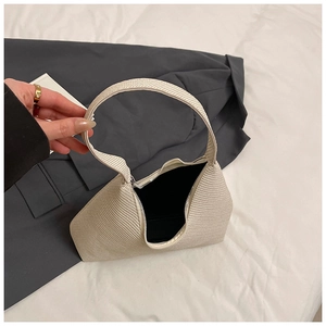Detail view of woven texture and black interior lining on a cream hobo shoulder bag