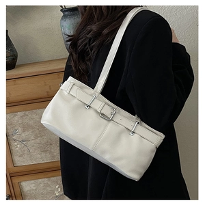 Detail of cream white PU leather shoulder bag with decorative buckle belt and metal eyelets