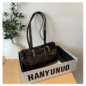 Detail view of deep coffee glossy leather shoulder bag with silver buckle and thin straps