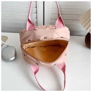 Vue de dessus d'un sac à main matelassé rose montrant sa grande capacité et sa doublure