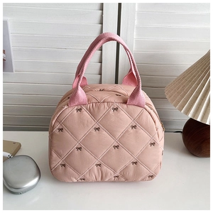 Détail du sac cabas matelassé rose avec broderie de nœud et poignées en tissu