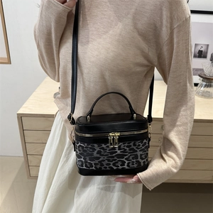 Sac boîte tendance avec imprimé léopard et détails dorés porté par un mannequin