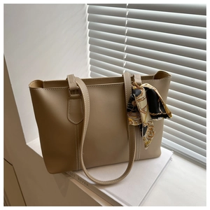 Detail einer khakifarbenen Shopper-Tasche mit modischem Seidentuch am Tragegriff