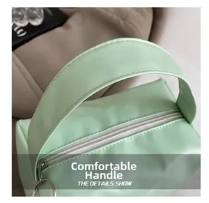 Detailed close-up of the mint green faux leather handle and silver zipper of this square bag