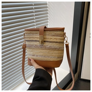 Detailed shot of woven bucket bag with leather trim and vintage metal turn-lock closure