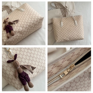 Detail of monogram tote bag with brown knit rabbit charm and secure zipper closure