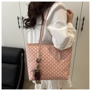 Bolso tote rosa con estampado de logos y colgante de osito en la correa de hombro
