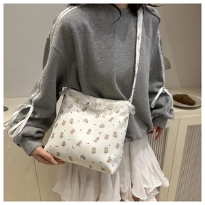 Detail of cute bear pattern and white lace trim on a stylish large PU leather crossbody bag