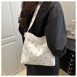 Detail of white lace tote bag featuring cartoon cat print and ruffle decorative edges