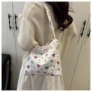 Detail of white floral canvas bag with cartoon bears, lace trim, and wide shoulder strap