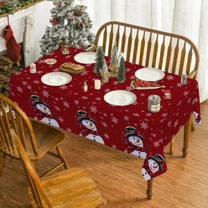 Detailed view of red Christmas tablecloth with snowman and snowflake prints on dining table