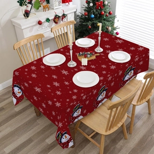 Detail of red Christmas tablecloth featuring cartoon snowman prints and white snowflakes