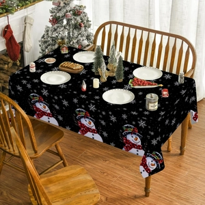 Detailed view of Christmas tablecloth featuring snowman prints and red plaid scarf accents