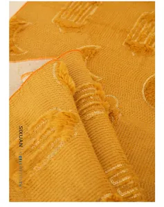 Close-up of mustard yellow table runner featuring plush flocking and sequin embroidery