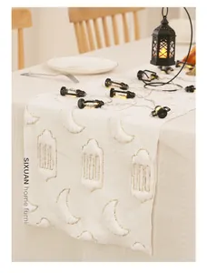 Detail of moon and lantern sequin embroidery with fringe on beige table runner