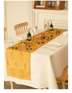 Detail of yellow Ramadan table runner with embroidered crescent moon and lantern patterns