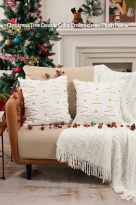 Detalle del bordado de árbol de Navidad y estrellas doradas en funda de cojín de felpa