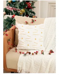 Detalle de funda de cojín navideño con bordado de estrellas doradas y flecos finos