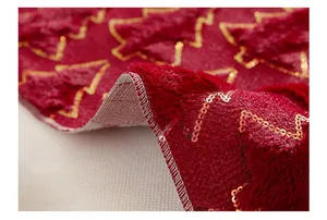 Close-up of durable stitched edges and gold sequin Christmas tree on red PV plush mat