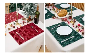 Detailed close-up of embroidered Christmas tree placemats in forest green and deep red velvet