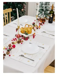 Detailed view of white Christmas placemat with gold star embroidery and holiday table decor