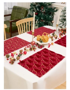 Detail of red Christmas placemat with gold tree embroidery on soft velvet fabric