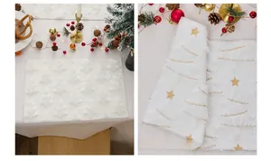 Detailed view of white Christmas placemats with gold tree embroidery and plush texture
