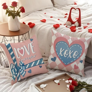 Fodere per cuscini rosa di San Valentino con stampe cuore e XOXO su letto di lino bianco