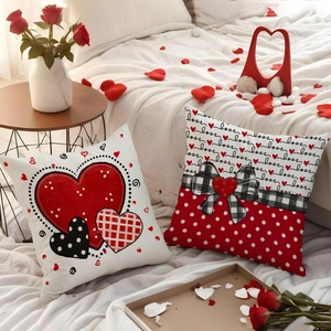Set of 2 Valentine's Day heart pillow covers with LOVE text and bow on a white bed
