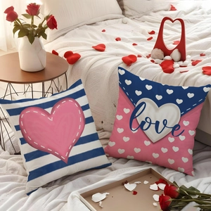 Valentine's Day heart throw pillow covers with Love script and stripe patterns on white bed