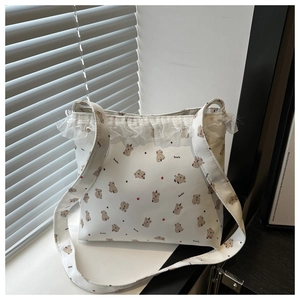Detailed view of white canvas tote bag with cute koala print and delicate lace ruffle edge