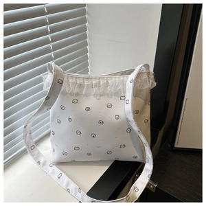 Detail of white tote bag featuring delicate lace trim and cute cartoon cat prints