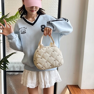 Sac à main matelassé beige avec broderie nœuds marron et motif de losanges chic
