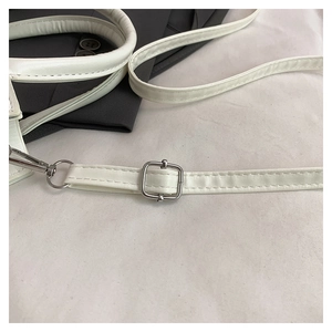 Detail of white leather shoulder strap with adjustable silver metal hardware and lobster clasp