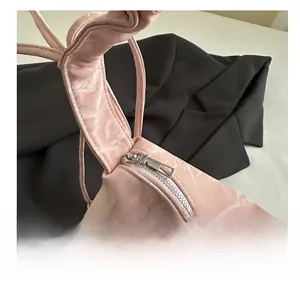 Gros plan d'une fermeture éclair en métal argenté sur un sac fourre-tout rose pâle