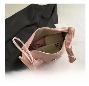 Sac cabas en daim rose montrant l'espace pour téléphone et portefeuille avec sangle