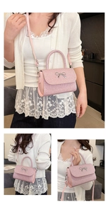 Detail of pink glitter crossbody bag featuring a delicate silver bow and adjustable strap