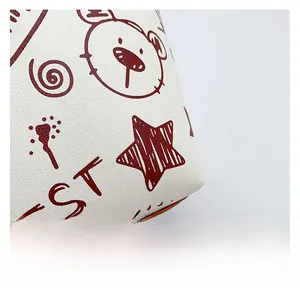 Macro shot of white synthetic leather texture with red star and bear cartoon prints