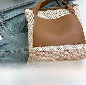 Detail of woven straw tote bag featuring brown leather pocket and textured summer style