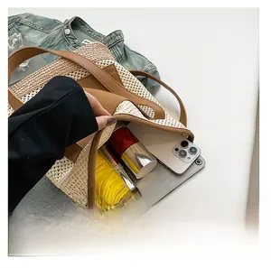Spacious interior of woven straw tote bag holding tablet, phone, and umbrella