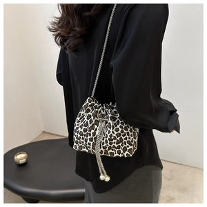Detail of leopard print bucket bag with drawstring closure and silver chain strap