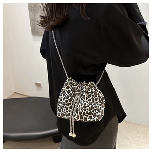Detail of leopard print bucket bag with metal chain strap and pearl drawstring charms