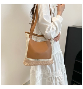 Detail of the woven texture and brown leather pocket on a beach tote bag