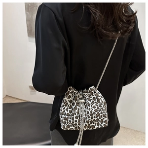 Detail of leopard print drawstring bucket bag with silver chain strap and metal ball decor
