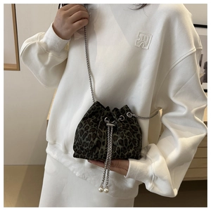 Detail view of leopard print bucket bag with silver chain and white pearl charms