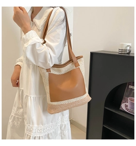 Straw tote bag with brown leather pocket and straps worn by model in white lace dress