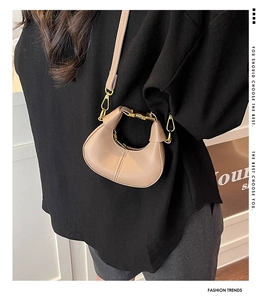 Close-up of beige crescent bag with premium leather texture and gold metal zipper detail