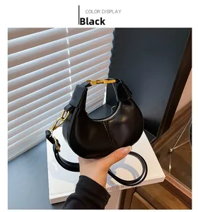Detailed shot of black mini crescent bag with gold chain and matte PU leather texture