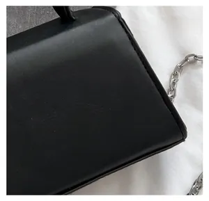 Close-up of fine texture black leather fabric and silver chain strap on fashion handbag